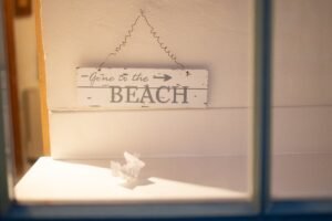 Wooden sign reading 'Gone to the Beach' hangs inside with soft lighting.