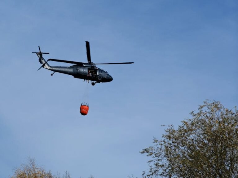 A helicopter conducting a firefighting operation in the clear skies above Wrocław, Poland.