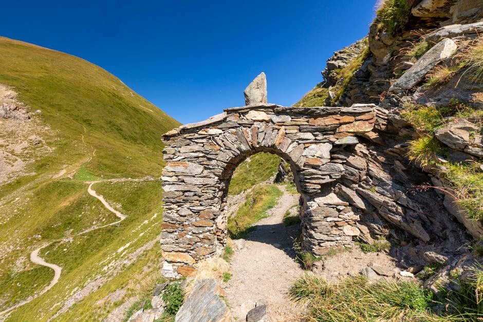 Explore a scenic stone arch on a hiking trail in the Auvergne-Rhône-Alpes region of France.