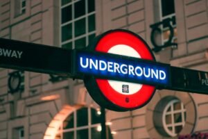 Close-up of the London Underground sign illuminated at night, highlighting a famous transport symbol.